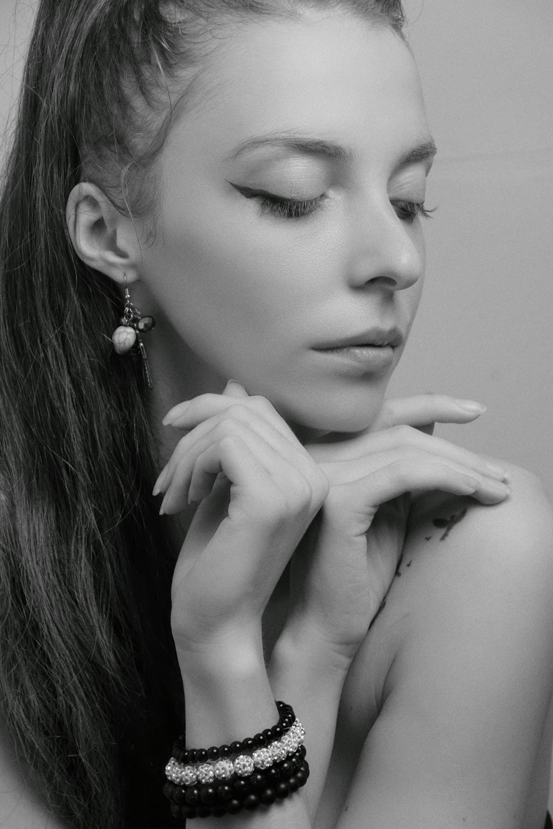 a woman with long hair wearing two bracelets