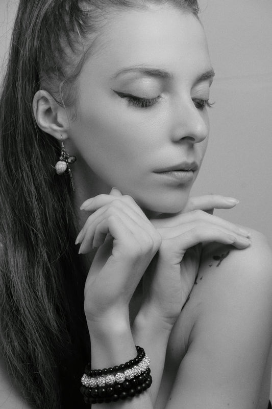 a woman with long hair wearing two bracelets