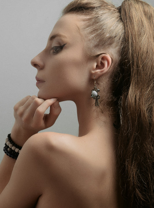a woman with long hair wearing a pair of earrings