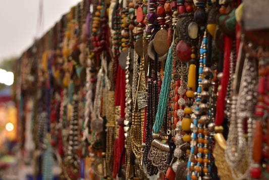 a bunch of necklaces are hanging on a wall