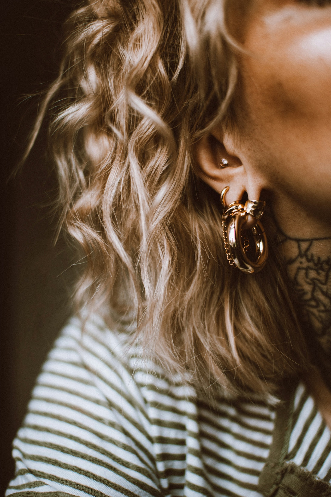 a close up of a person wearing a pair of earrings
