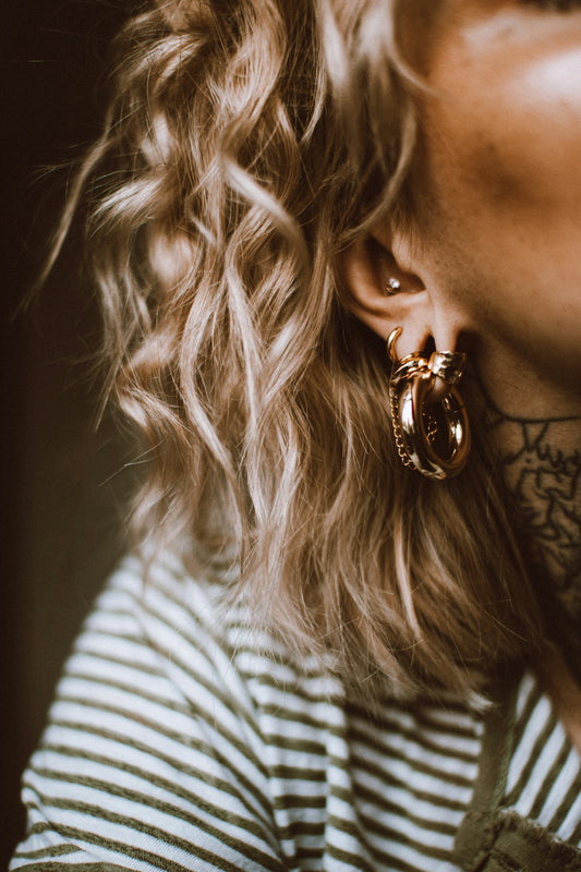 a close up of a person wearing a pair of earrings