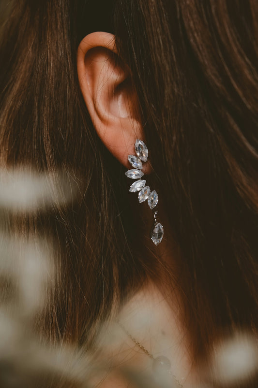 a close up of a woman's ear wearing a pair of earrings