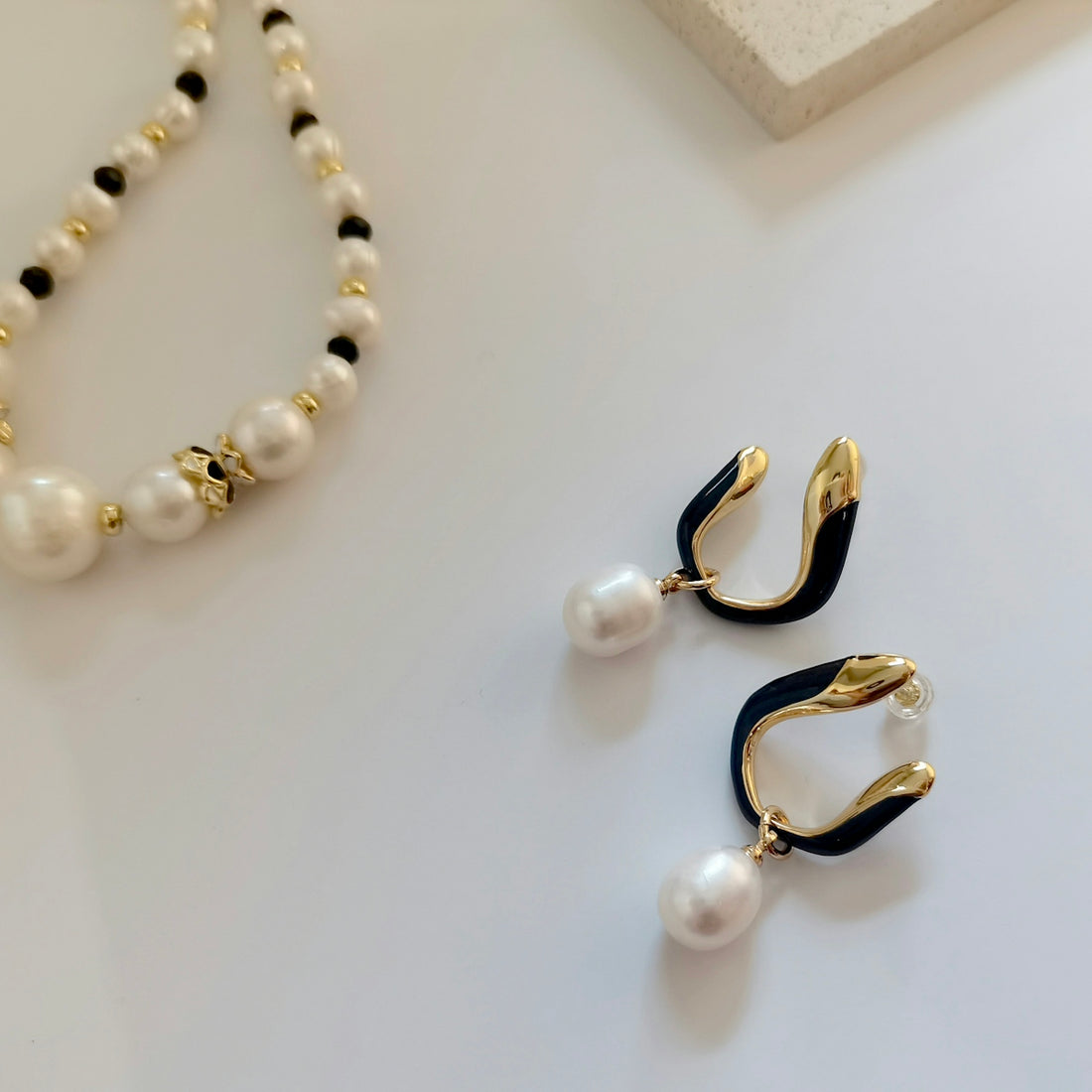 a pair of pearls and a necklace on a table