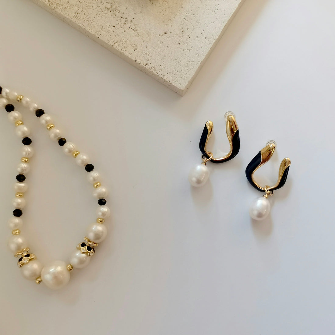 a pair of earrings and a necklace on a table