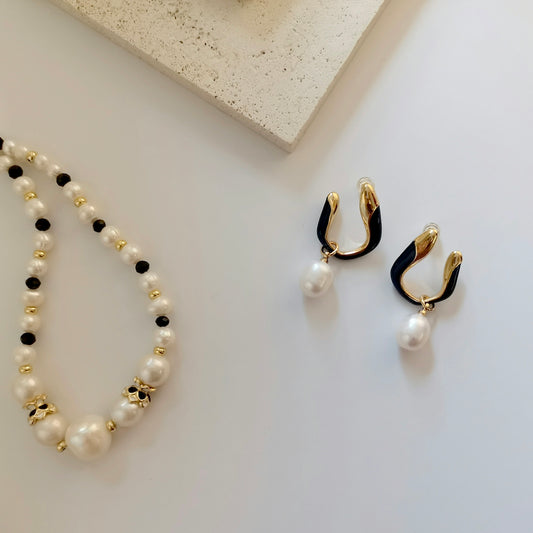 a pair of earrings and a necklace on a table