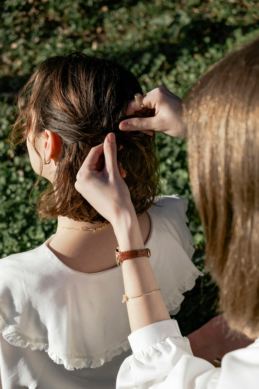 A woman in a white shirt is combing her hair