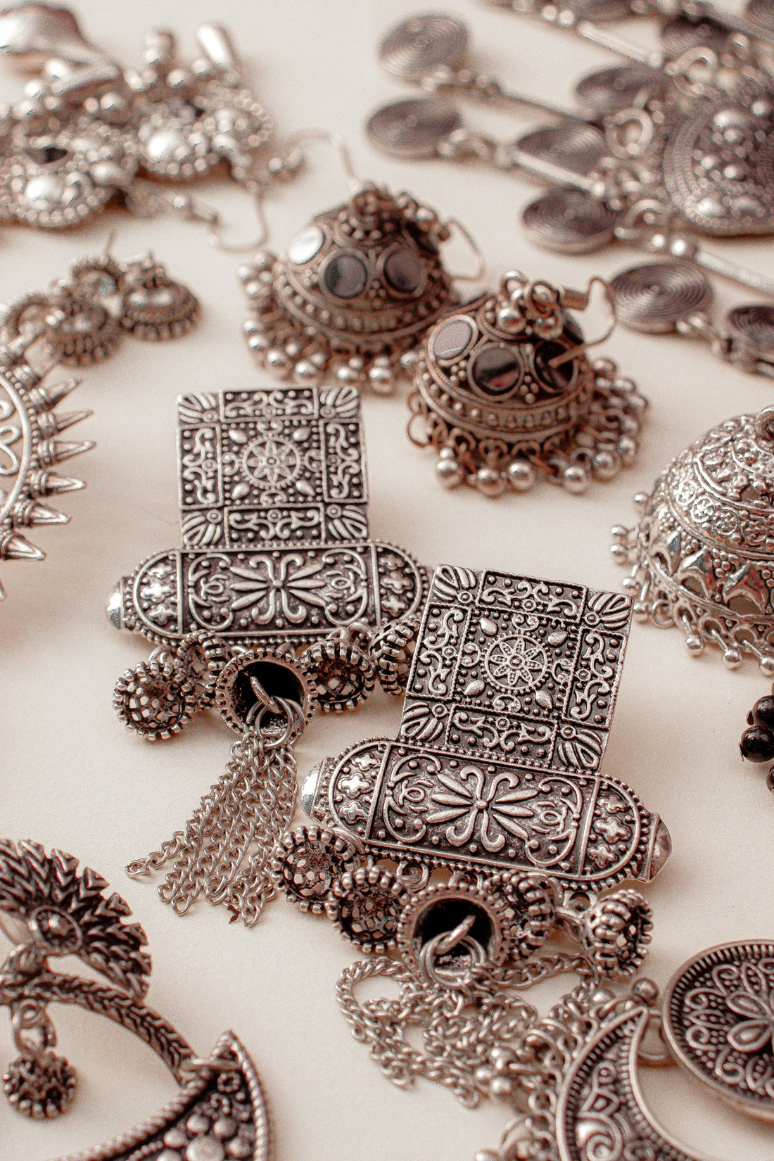 A table topped with lots of silver jewelry