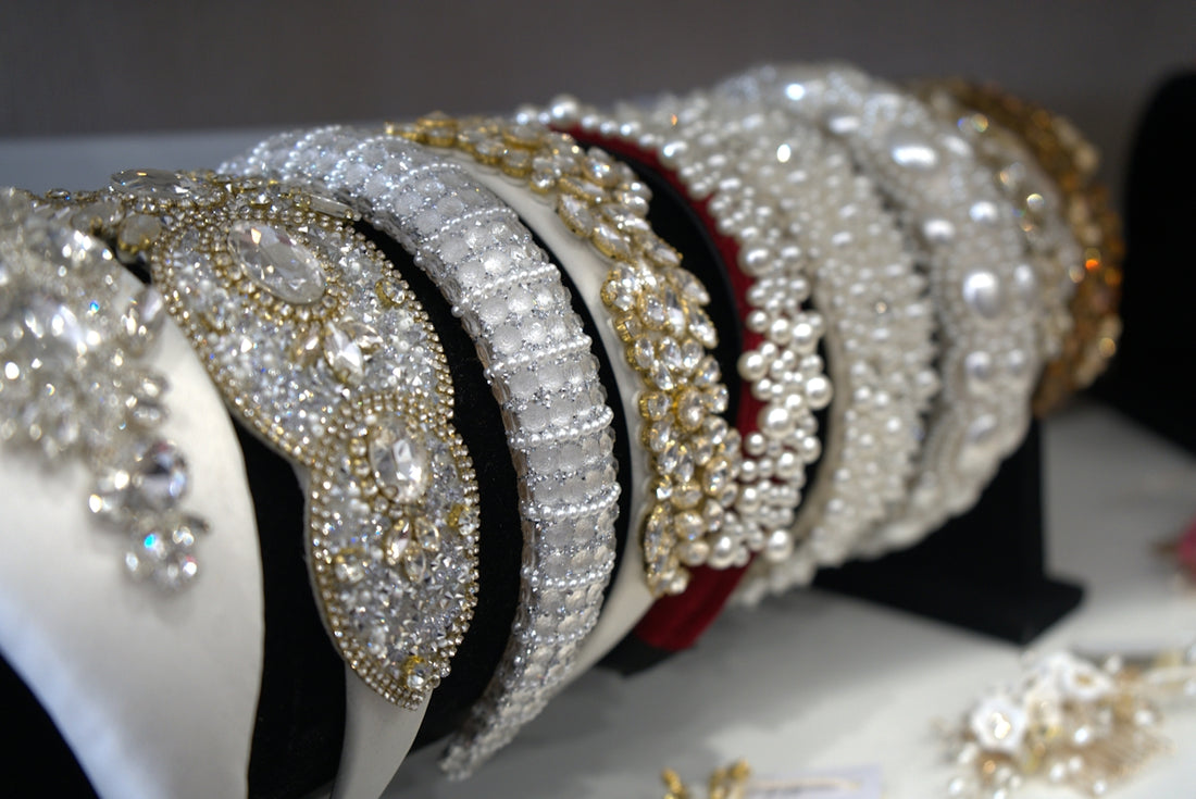 Beautiful, beaded headbands are displayed on a shelf.