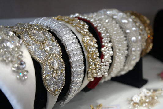 Beautiful, beaded headbands are displayed on a shelf.