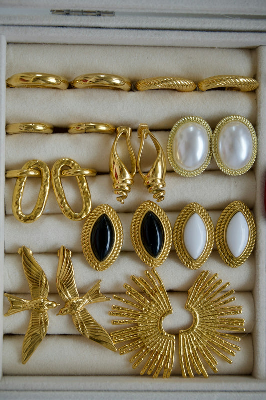 Collection of assorted gold earrings and jewelry in a box
