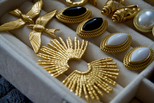 Collection of vintage gold earrings with gemstones and pearls.